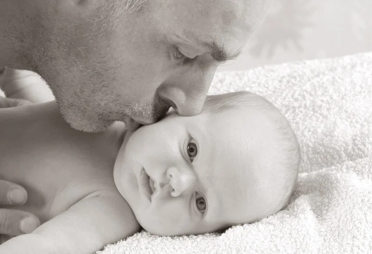 Dad kissing his new born baby